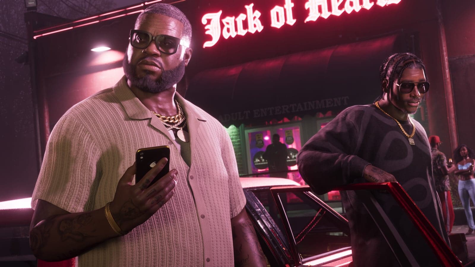 Boobie Ike with a phone in his hand outside the Jack of Hearts, Dre’Quan leaning on a car behind him