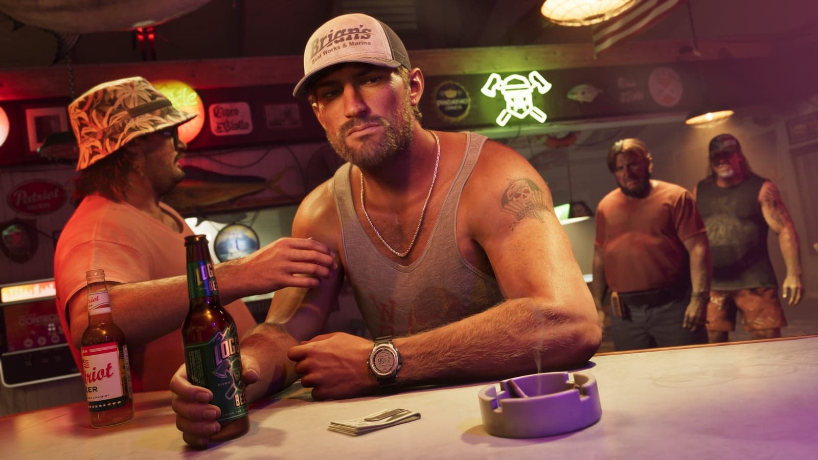 Jason in a Brian’s Boat Works cap leans on a bar with a beer, a bottle of Patriot beside him