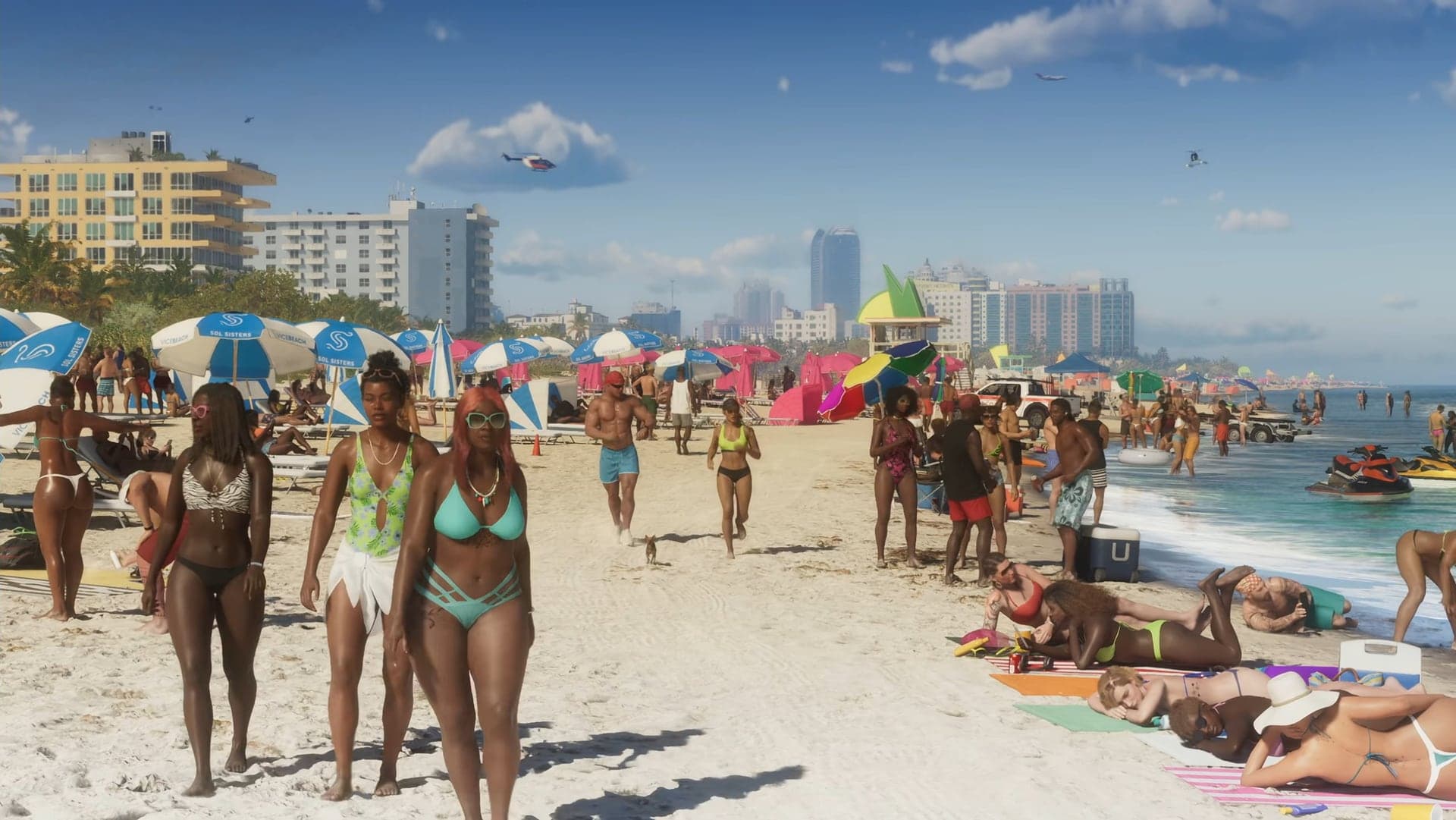 Vacationers walking along a crowded beach with umbrellas and high-rises in the distance