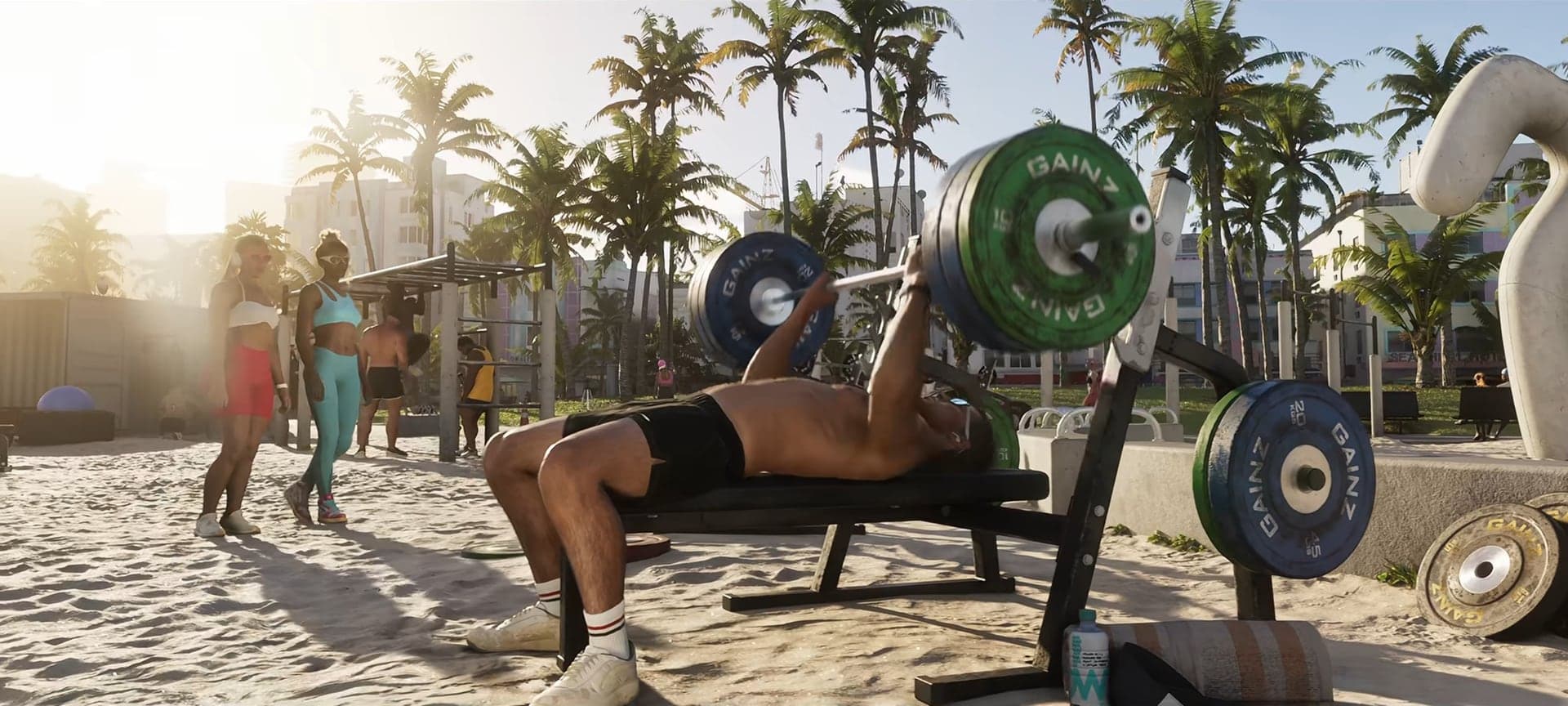 A man lifting a barbell at an outdoor gym on the beach