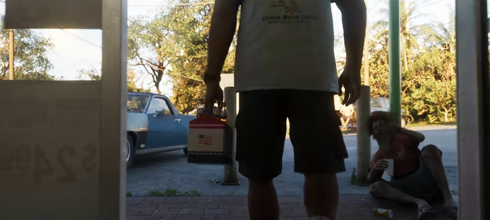 A man with a red gas can stepping out of a store, a man sitting on the ground outside