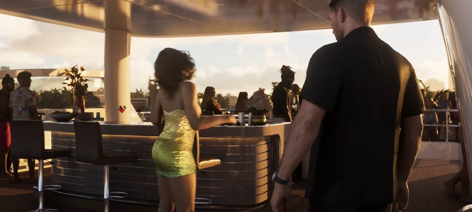 A woman in a gold dress at a terrace party by the water, a man in black beside her