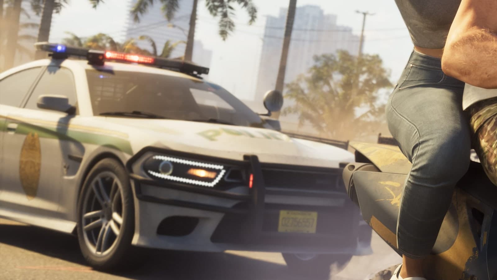 A police car with its light bar on chases Jason and Lucia’s motorcycle